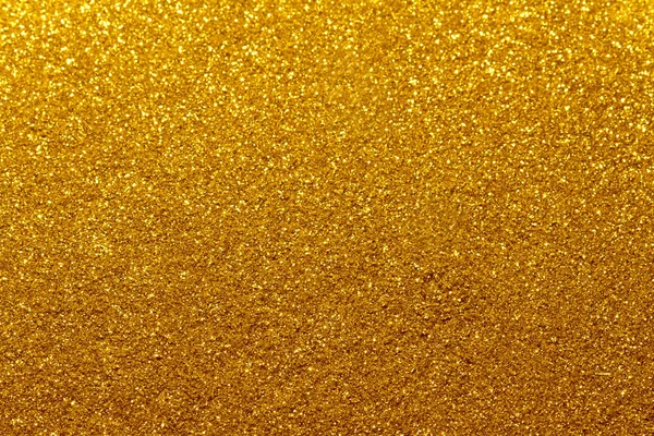 Abstract golden glitter background with shining light and soft bokeh, festive colors