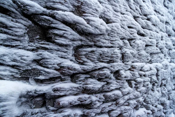 El muro de piedra en invierno, cubierto de heladas de cerca — Foto de Stock