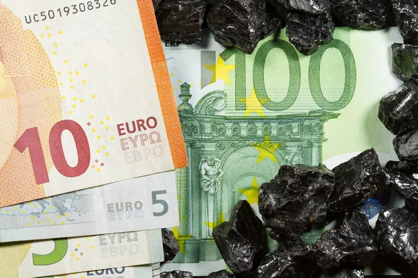 Notas de euro sobre pepitas de carvão em bruto, letras sobre carvão, poder do mone — Fotografia de Stock