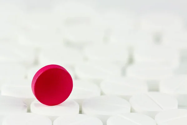 Red pill on white pills background. Conceptual exclusion of pill — Stock Photo, Image