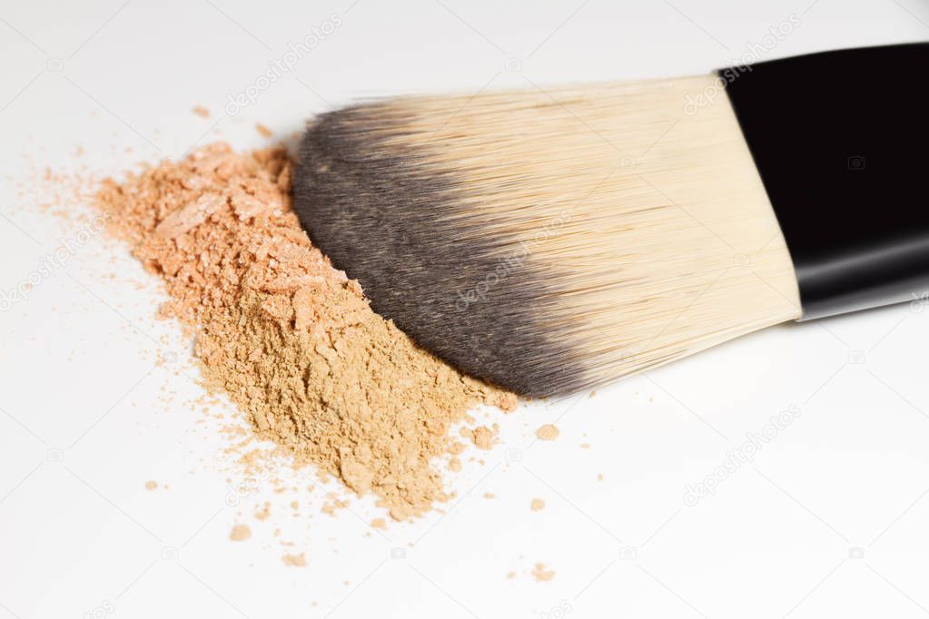 Makeup brush with powder foundation isolated on white