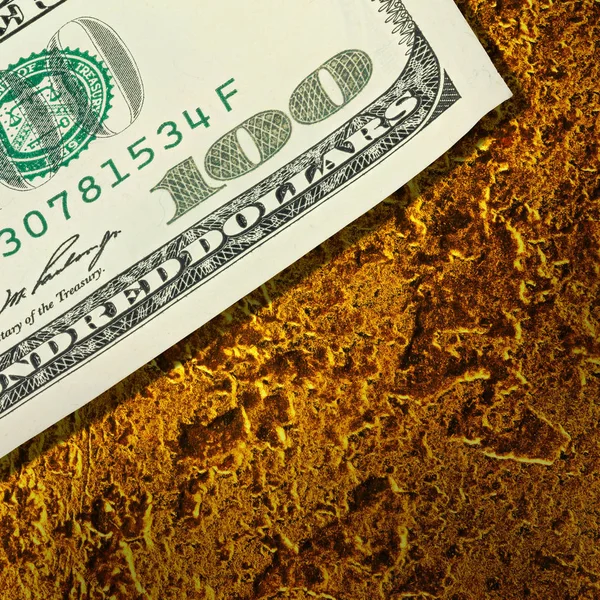 Dollars banknotes on golden nuggets close up — Stock Photo, Image