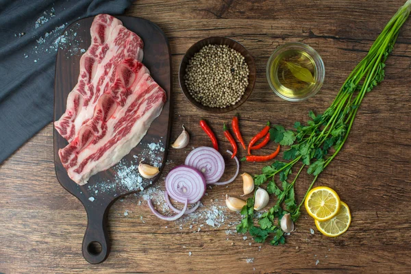 Rohes Steak mit Gewürzen auf Holzgrund. — Stockfoto