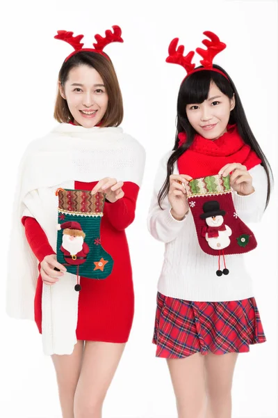 Dwie Młode Kobiety Trzymające Świąteczne Pończochy Uśmiechnięte Kamery Białym Tle — Zdjęcie stockowe