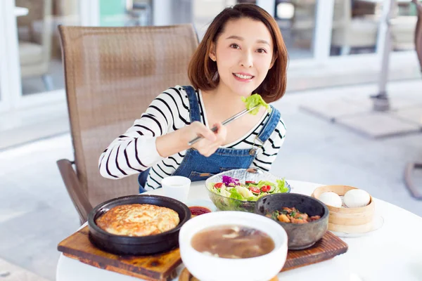 Donna felice mangiare fuori in un ristorante stock foto — Foto Stock