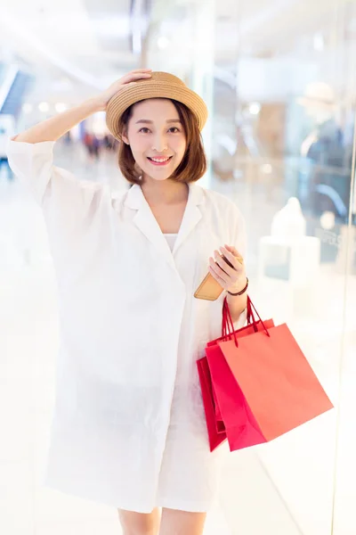 Vacker Flicka Med Shoppingväskor Ler Mot Kameran Köpcentrum — Stockfoto