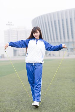 Şirin Çinli lise öğrencileri kampüste oyun parkında öğreniyor.