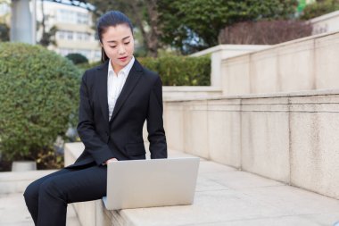 Güzel kız dışarıda dizüstü bilgisayar kullanan bir devlet memuru.