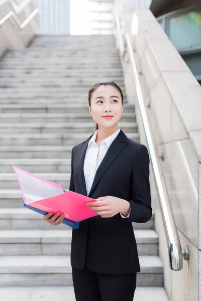 Joven Secretaria Vistiendo Traje Negro Sosteniendo Una Carpeta —  Fotos de Stock