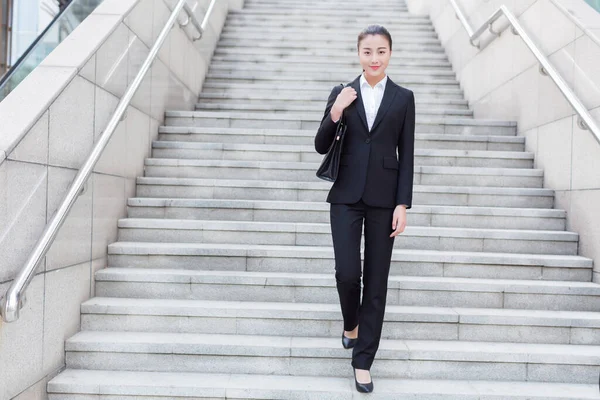 young female secretary wearing a black suit, carrying a briefcase
