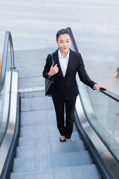 young female secretary wearing a black suit, carrying a briefcase