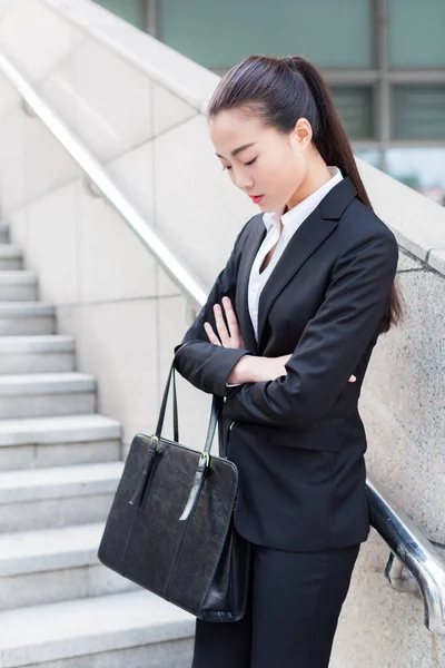 young female secretary wearing a black suit, carrying a briefcase