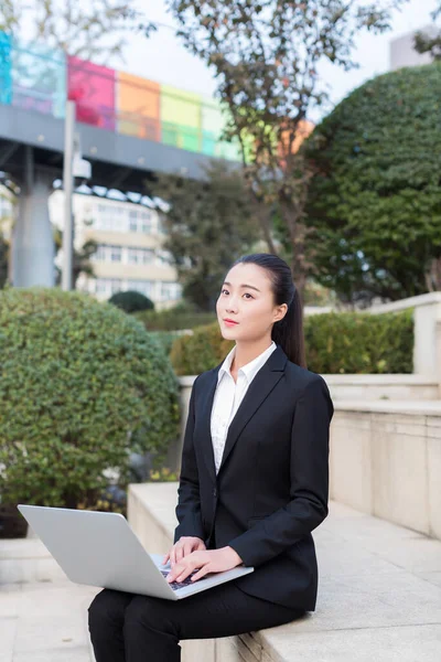 pretty girl is a civil servant, using laptop outdoors