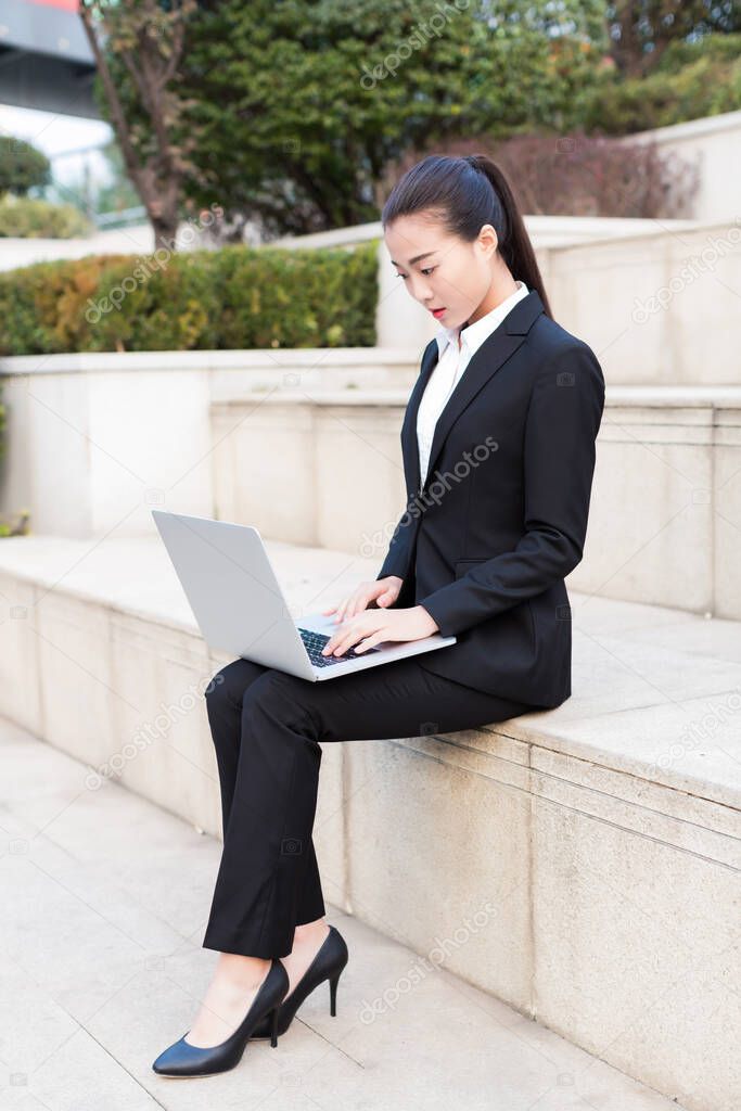 pretty girl is a civil servant, using laptop outdoors