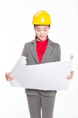 Porselen, güzel bayan mimar, şantiyede bir çizim tutuyor.