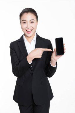 Siyah takım elbiseli güzel Çinli kız elinde cep telefonu tutuyor.
