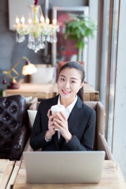 Kahve dükkanında dizüstü bilgisayar kullanan güzel bir kız.