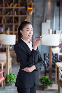 Beyaz yakalı işçiler onun cep telefonunu kullanmak için bir kafede duruyorlar.