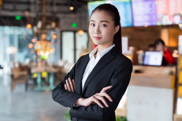 漂亮的中国姑娘穿着黑色西服 站在餐馆里 — 图库照片
