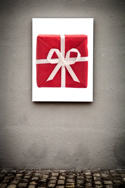 Vertical White Board and Red Gift Box, On Grungy Gray Wall — Stock Photo, Image