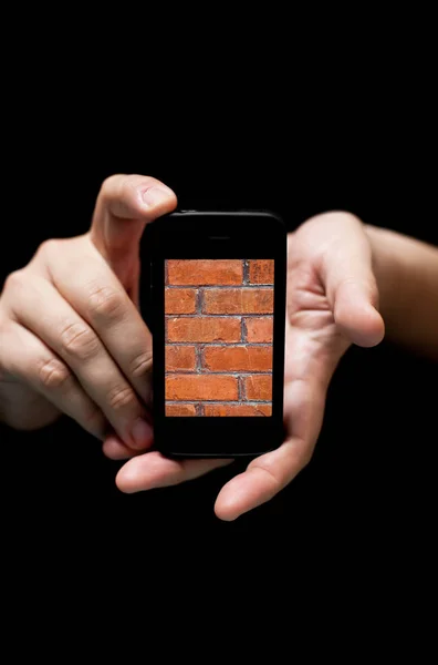 Manos sosteniendo Smartphone, mostrando la pared de ladrillo rojo — Foto de Stock