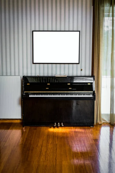 Viejo piano negro con tablero blanco vacío por encima de él —  Fotos de Stock