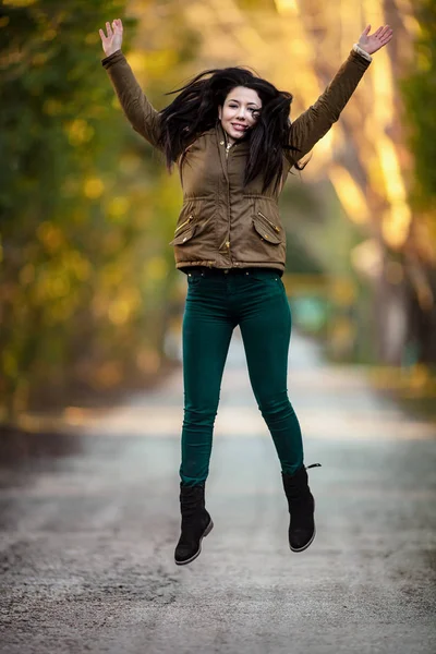 Молодая женщина с положительной энергией и красивой улыбкой прыгает на — стоковое фото