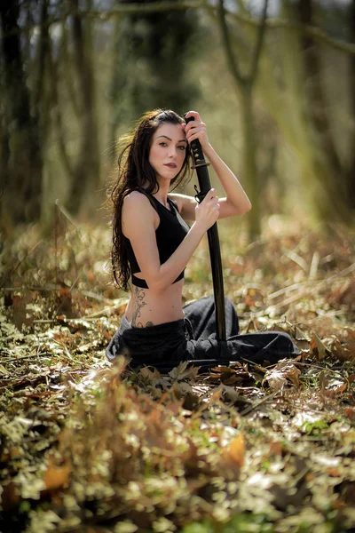 Vrouw-Warrior Katana zwaard, bedrijf in Mystic Forest Rechtenvrije Stockfoto's