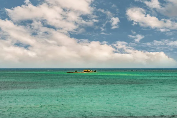 美しい夏空の下、海で最小の島 ストック画像