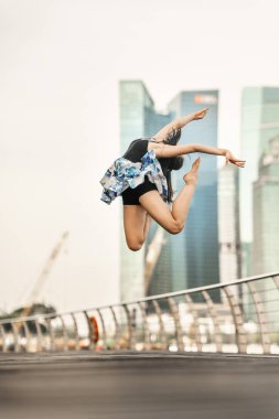 Canlı yayında dans... Güzel genç dansçı poz, perfoming mükemmel atlama, gökdelenlerin arka plan 