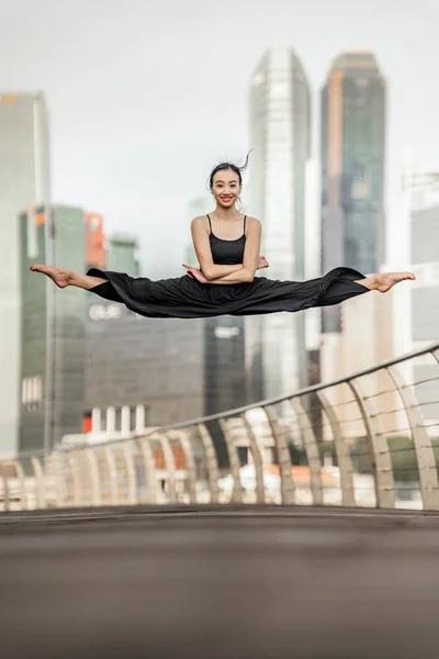 Leuke jonge vrouw atleet voert een perfecte straddle sprong hoge u — Stockfoto