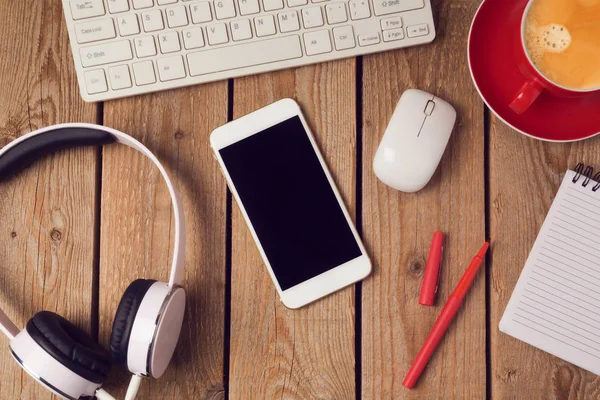 Mesa de oficina con smartphone y auriculares —  Fotos de Stock