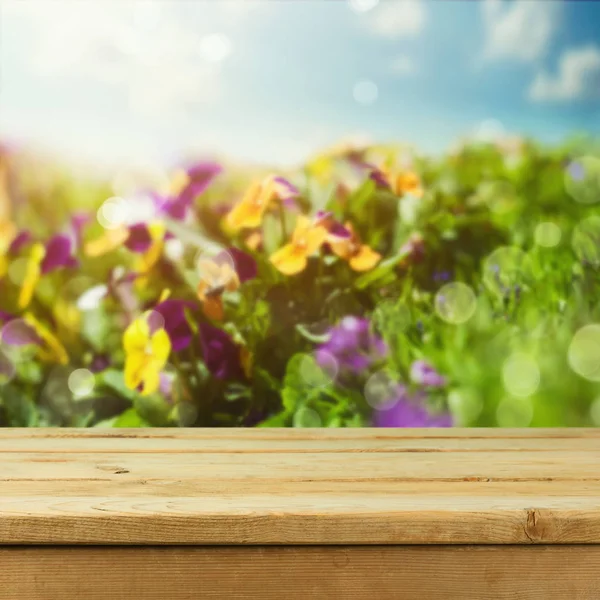 Table over flowers bokeh background — Stock Photo, Image