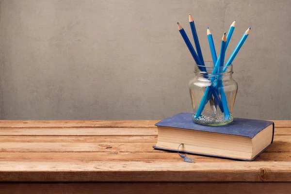 Книга та олівці в скляній банці — стокове фото