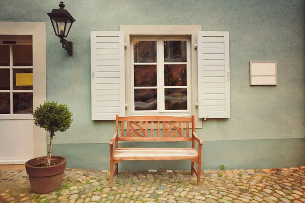 Деревянная скамейка на стене здания — стоковое фото