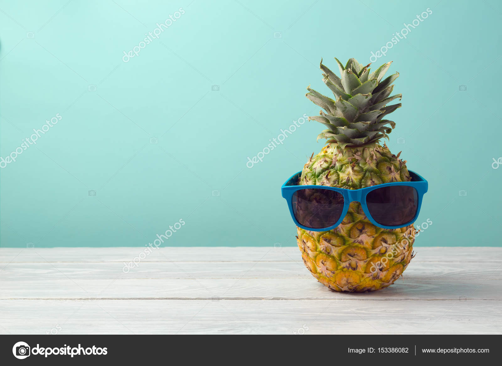 Pineapple with sunglasses on wooden table — Stock Photo © maglara
