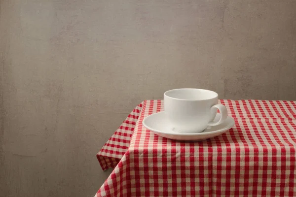 Copo branco vazio na toalha de mesa — Fotografia de Stock