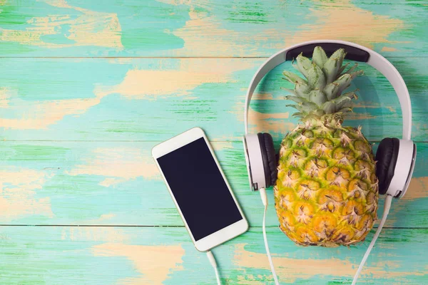 Ananas med hörlurar och smart phone — Stockfoto