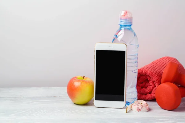 Wasser, Hanteln, Apfel und Smartphone — Stockfoto