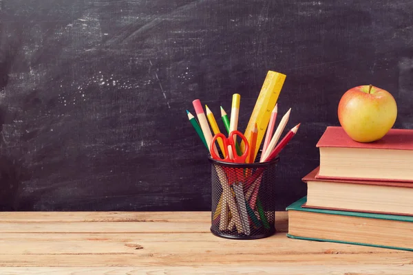 Boeken, potloden en apple over schoolbord — Stockfoto