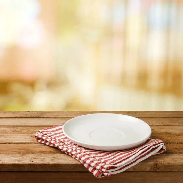 Empty white plate on wooden table — Stock Photo, Image