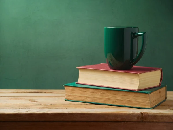 Зелена чашка кави на стопі книг — стокове фото