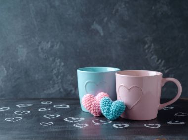 Bardak ve kalp şekilleri üzerinde kara tahta arka plan ile Sevgililer günü kavramı