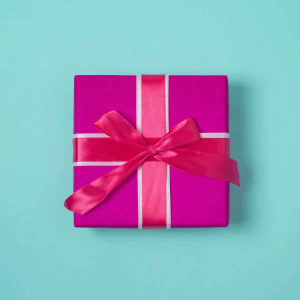 蓝色背景的粉红色蝴蝶结礼品盒 顶部视图 — 图库照片