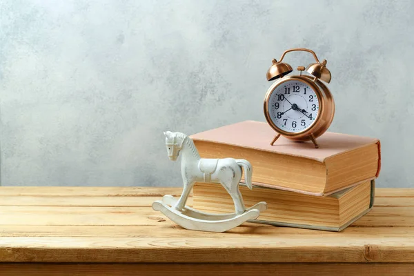 Boeken, wekker en schommelpaard — Stockfoto