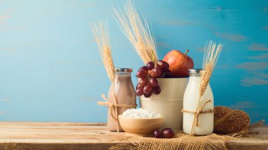 Süt, çikolatalı süt şişeleri ve ahşap masa üzerinde meyve. Yahudi tatil shavuot kavramı.