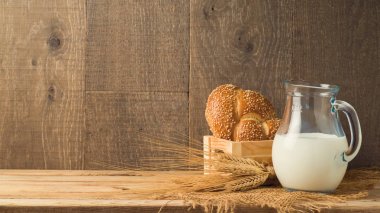 Süt sürahi ve ahşap masa ekmek. Yahudi tatil shavuot kavramı.