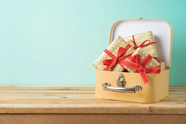 Holiday shopping concept with gift boxes in suitcase on wooden t — Stock Photo, Image