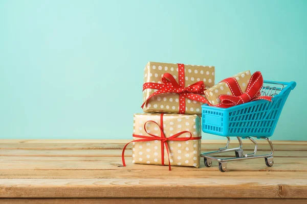 Winter holidays sale concept with gift boxes and shopping cart o — Stock Photo, Image