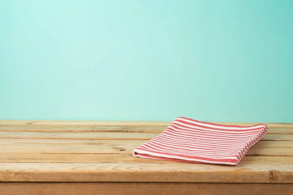 Leerer Holztisch mit Tischdecke über blauem Hintergrund — Stockfoto
